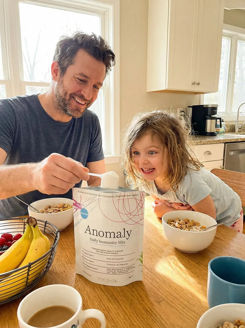 Dad scooping Anomaly into breakfast with his daughter