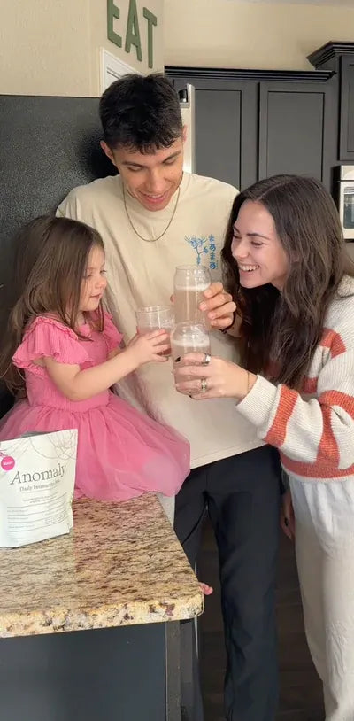 Family toasting with Anomaly smoothies in the kitchen